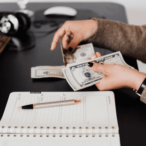 Person counting money sitting at desk